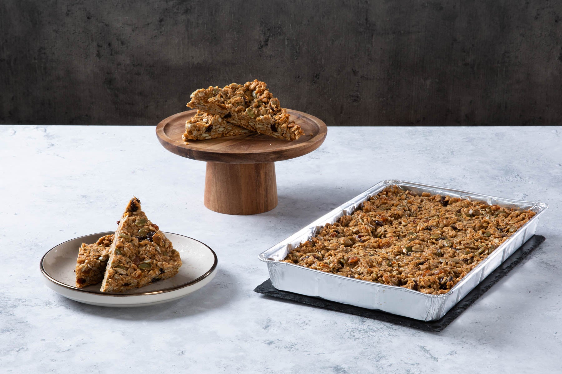 Chocolate cake with creamy frosting and chocolate topping on a wooden board.